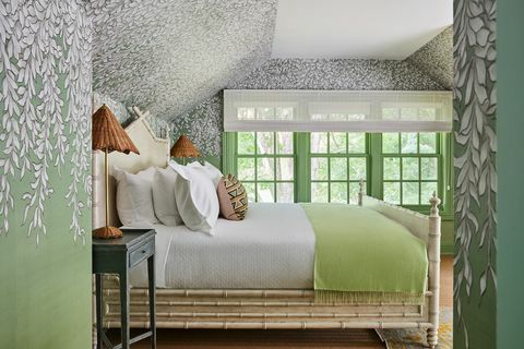 grüne Wände mit weißen Blumen und grüner und weißer Bettwäsche