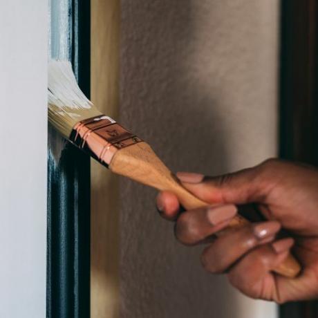 Frauenhände malen mit einem Pinsel