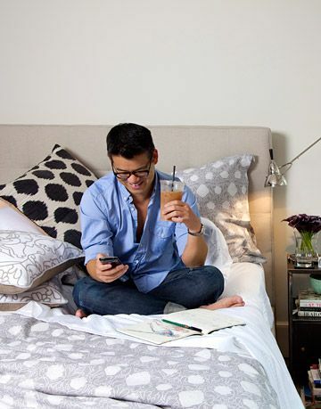 Peter Som sitzt in seinem Bett und schreibt eine SMS