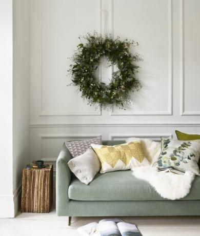 Winterwunderland blassgrünes Sofa und ein Weihnachtskranz, der über der natürlichen Schönheit hängt Moos, ab 2.395 £, Designer-Zunftkissen l r länglich in Mergel-Platin, 75 Mio Quadrat in Larochezinc, £ 87 Mio., Designergilde mit Lederpaspel in Silber, £ 36 Mio., Samuel Sons Geotile in Chartreuse, £ 110, Niki Jones Adachi Seladon, £ 85, Designerguild Schaffell-Teppich, £ 80, Cox Cox Twig Vertikalsäulen-Beistelltisch, £ 875, Prise Atro City kleine Tasse, £ 46 gewöhnlicher kleiner Teller, £ 24 beide Emma Johnsonceramics Buch, eigene Stylistin