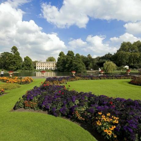 Bunte Blumenbeete in den wunderschön gepflegten Botanischen Gärten von Kew mit Blick auf den See, Richmond upon Thames, Surrey, England