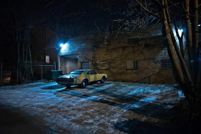 Oldtimer-Muscle-Car in einer dunklen städtischen Gasse der Stadt Chicago in einer Winternacht