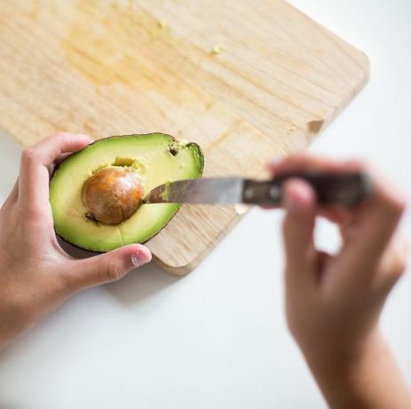 Kind nimmt den Stein aus einer Avocado