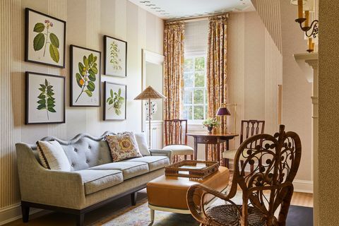Wohnzimmer mit Korbstühlen, cremefarbene Couch, Gemälde von Blättern