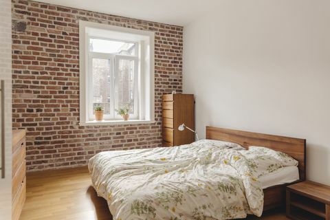 Schlafzimmer im modernen Gebäude mit Backsteinmauer