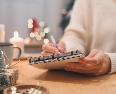 Ziele Pläne machen und Wunschliste für das neue Jahr Weihnachtskonzept schreiben in Notizbuch Frau Hand hält Stift auf Notizblock zu Hause an den Winterferien Weihnachten