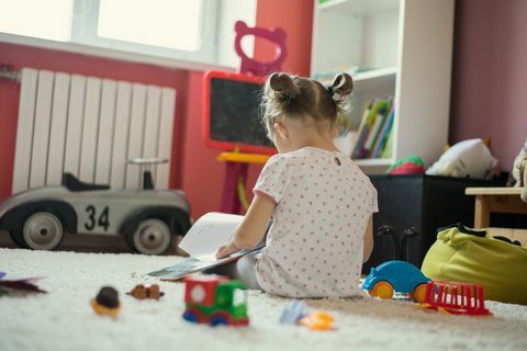 Buch des kleinen Mädchens Lesein dem Kinderraum.