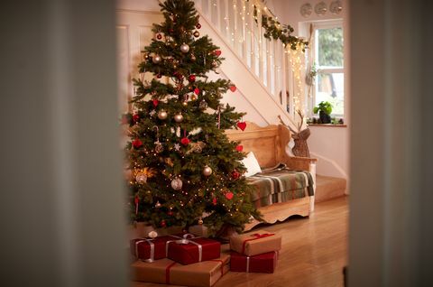 Flur des Hauses verziert für Weihnachten mit dem Baum und Geschenken angesehen durch offene Tür