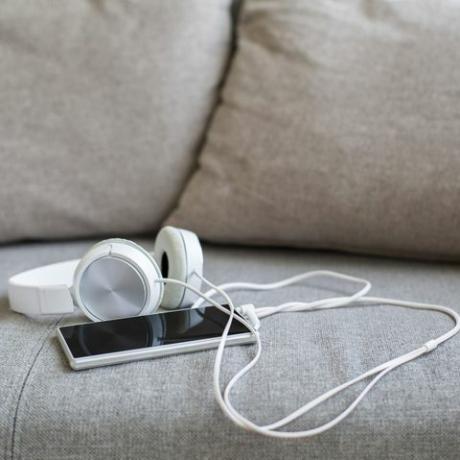 Kopfhörer und Smartphone auf dem Sofa