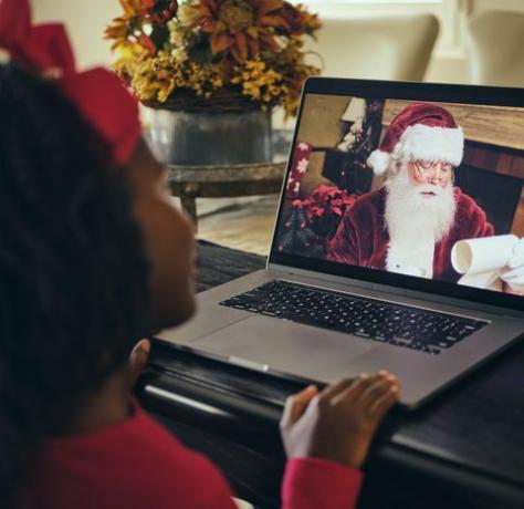 Ein kleines Mädchen, das mit dem Weihnachtsmann in einer Computer-Video-Telefonkonferenz spricht