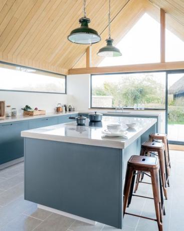 Blaue Küche mit Frühstückstheke und Holzdach