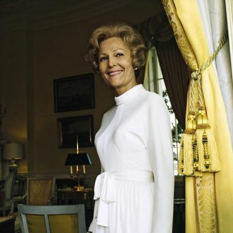 vogue, 15. oktober 1972 porträt von pat nixon nee thelma catherine patricia ryan first lady der vereinigten staaten und frau von präsident richard milhous nixon, die im gelben ovalen zimmer steht Von dem weißen Haus neben einem gelben Vorhang, der von großen Quasten zurückgehalten wird, trägt sie ein weißes Kleid mit langen Ärmeln, einem Stehkragen und einem Taillengürtel Bilder