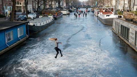 Dutzende von Menschen laufen auf den Amsterdamer Grachten