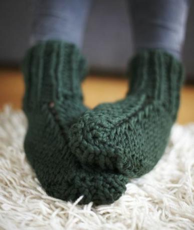 Paar Füße in grünen Socken gestrickt