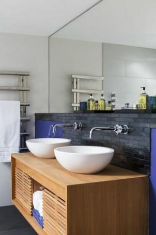 Waschtischunterschrank mit weißen Spülbecken und grauem Hintergrund