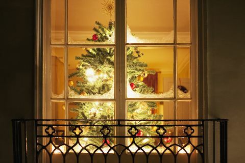 Weihnachtsverzierungen auf Baum hinter Fenster