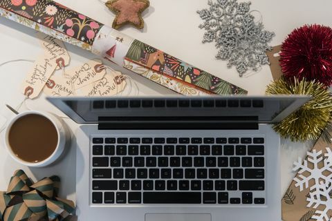 Laptop, Kaffee, Geschenkpapier und Weihnachtsschmuck