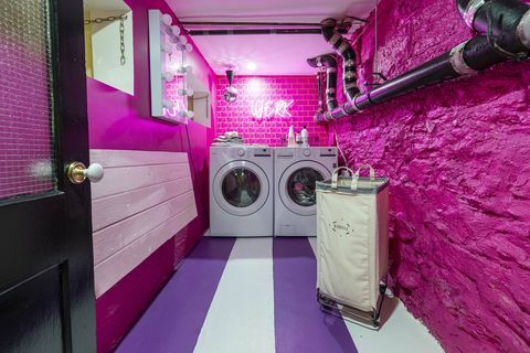 Wäsche, rosa Backsteinmauer, Neonreklame, lila und weiß gestreifter Boden